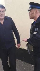 Shinners, angered by the protests tries to engage a police officer to help hiim get rid of the protestors - to no avail