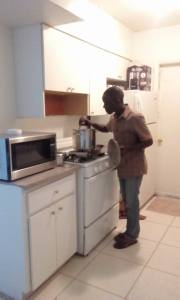 Andrew Standing in his new kitchen, shared with 3 other refugees from African countries.